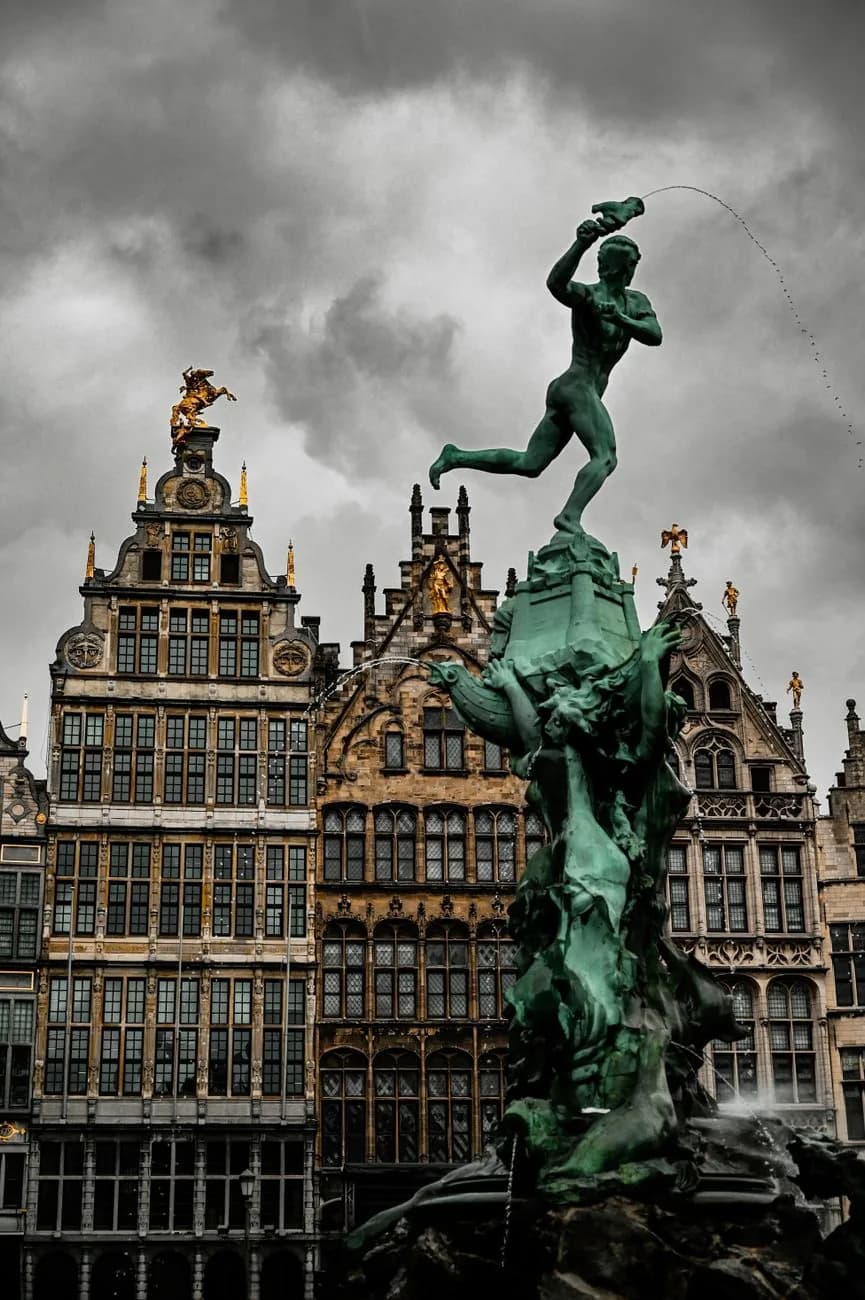 La fontaine Brabo devant les maisons de corporation de la Grote Markt d'Anvers, sous un ciel d'orage