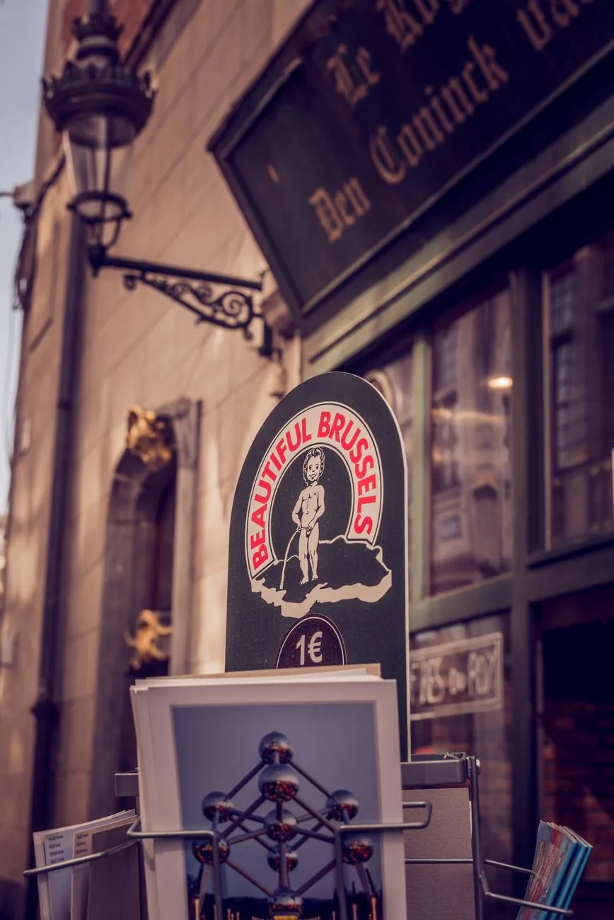 Présentoir de cartes postales et de souvenirs bruxellois devant la devanture d'une boutique