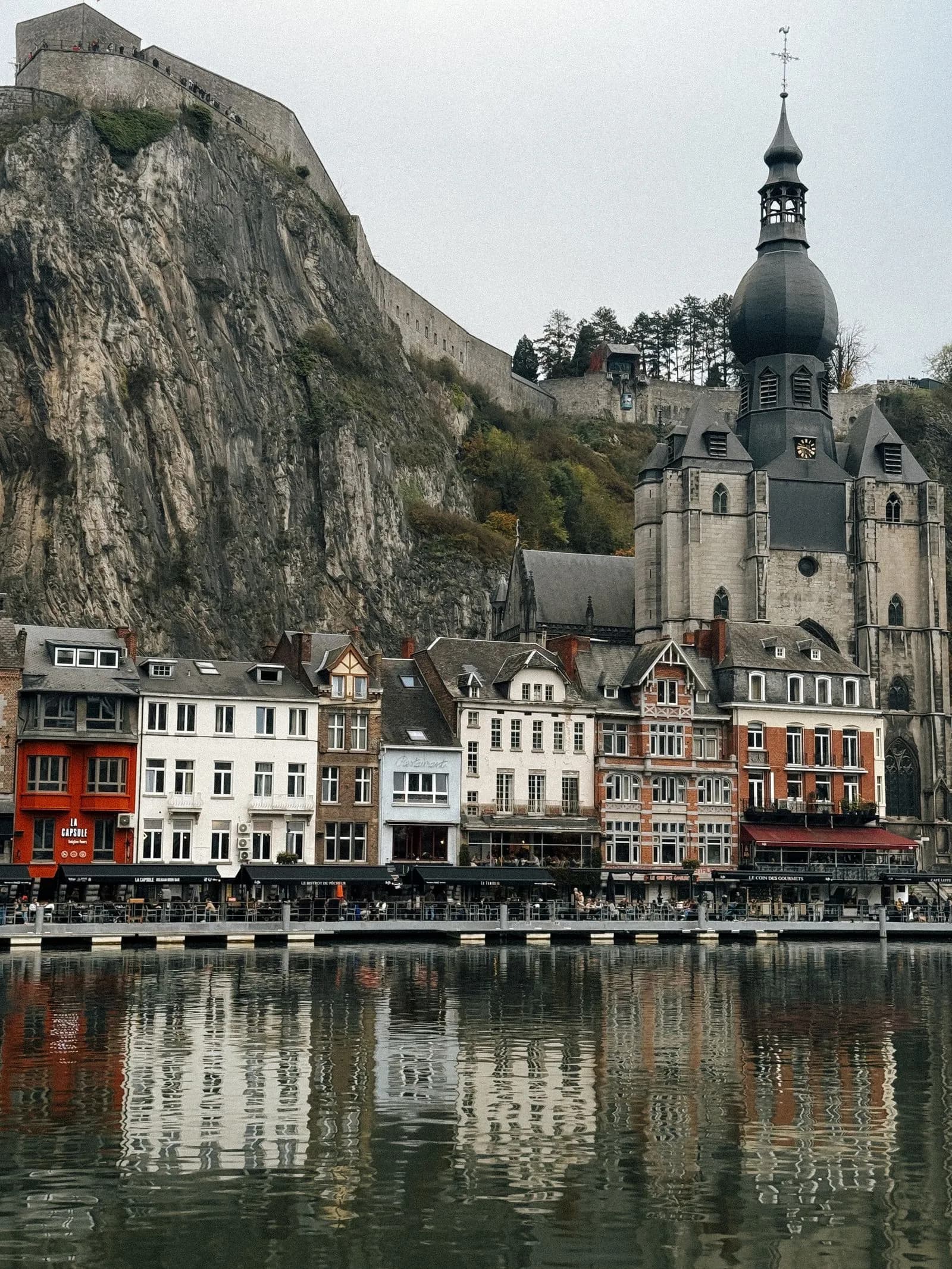 La citadelle de Dinant et ses remparts au sommet de la falaise calcaire, au-dessus des maisons du quai et de la collégiale