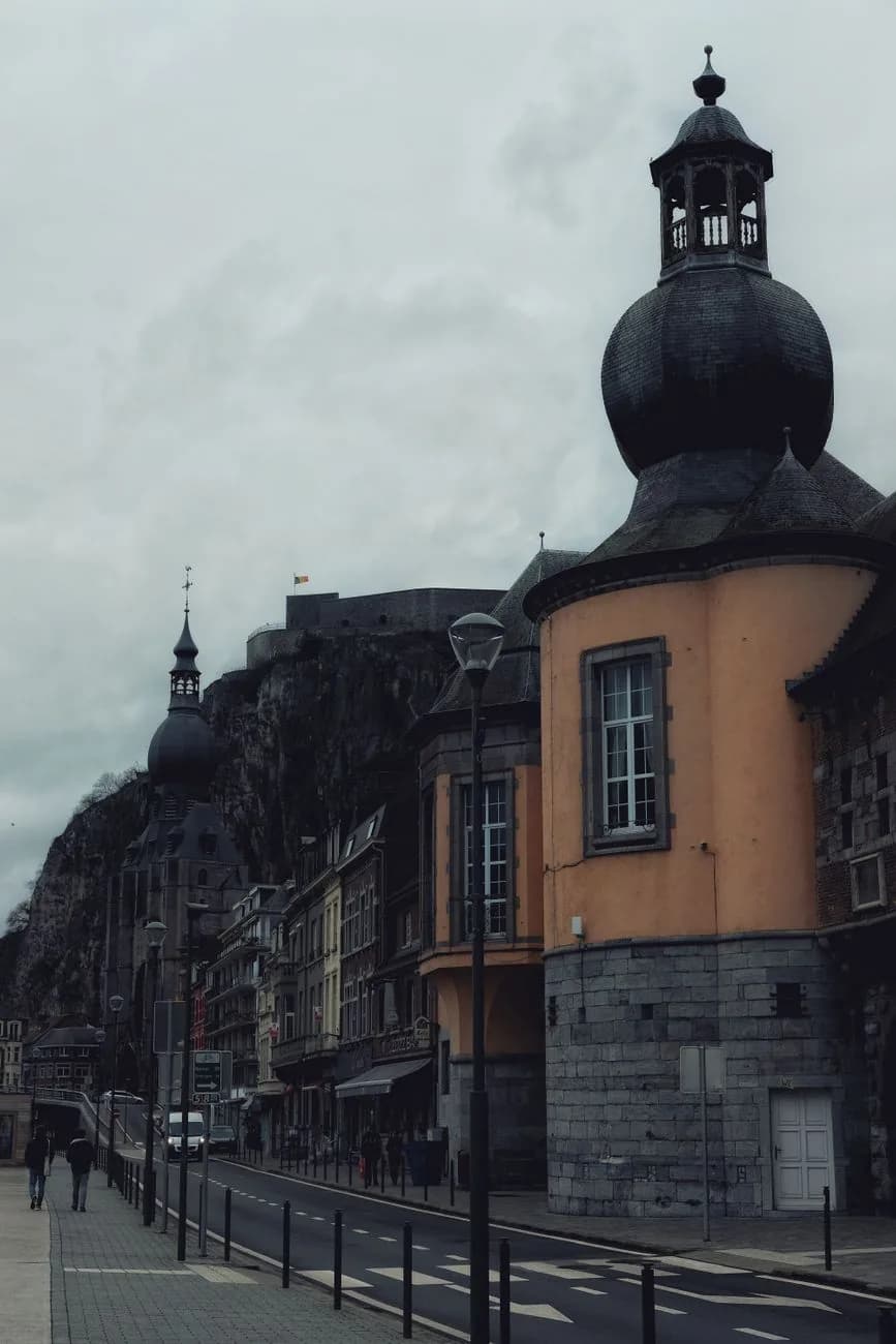Rue de Dinant longeant la falaise, le clocher bulbeux de la collégiale et la citadelle au sommet du rocher