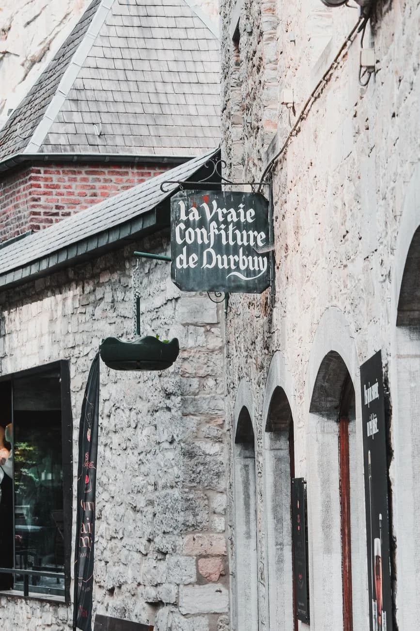 Enseigne « la Vraie Confiture de Durbuy » accrochée à une façade en pierre dans une ruelle du bourg