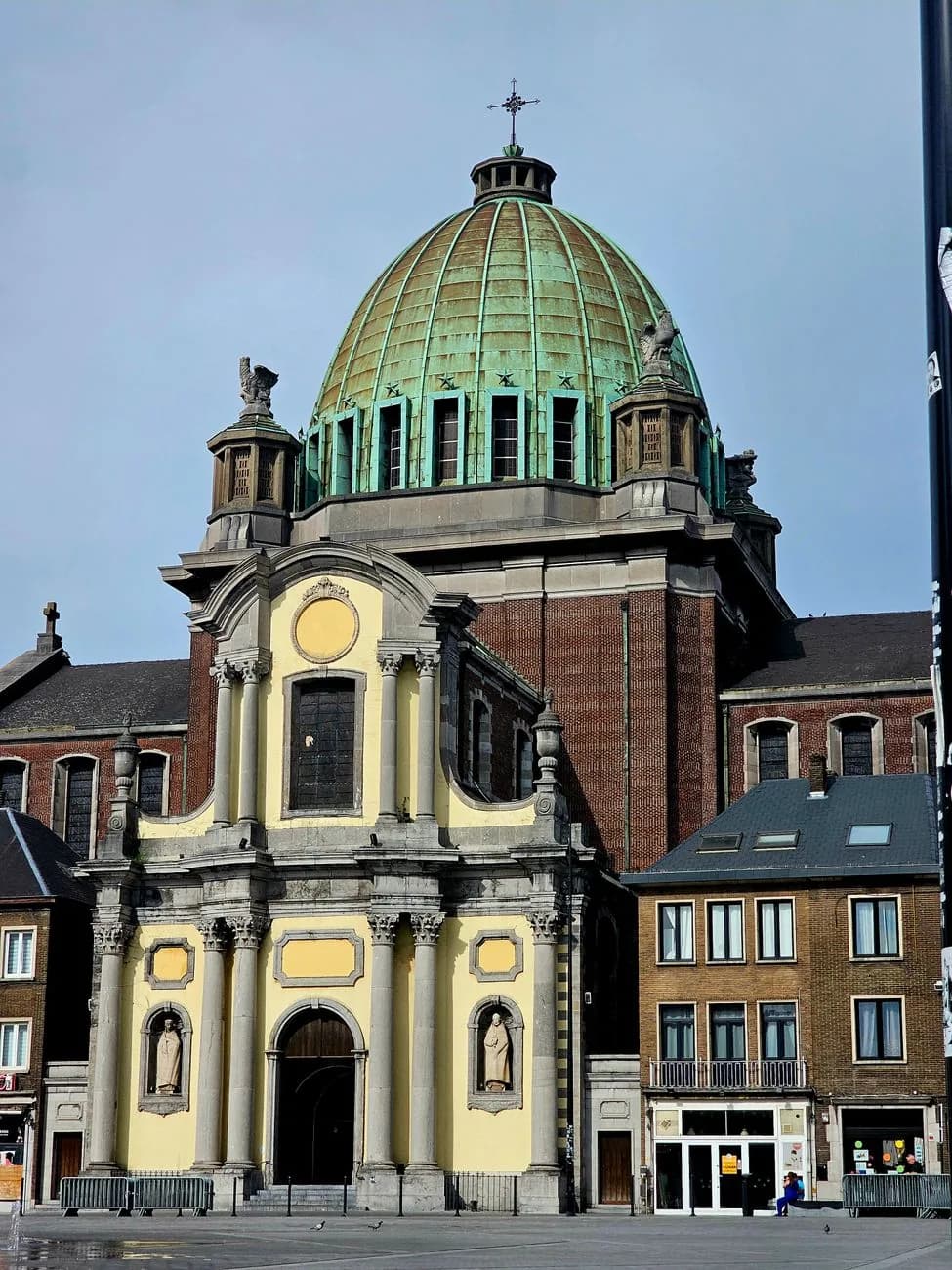 Façade baroque de la basilique Saint-Christophe surmontée d'un large dôme de cuivre vert, au bord de la grande esplanade pavée de Charleroi
