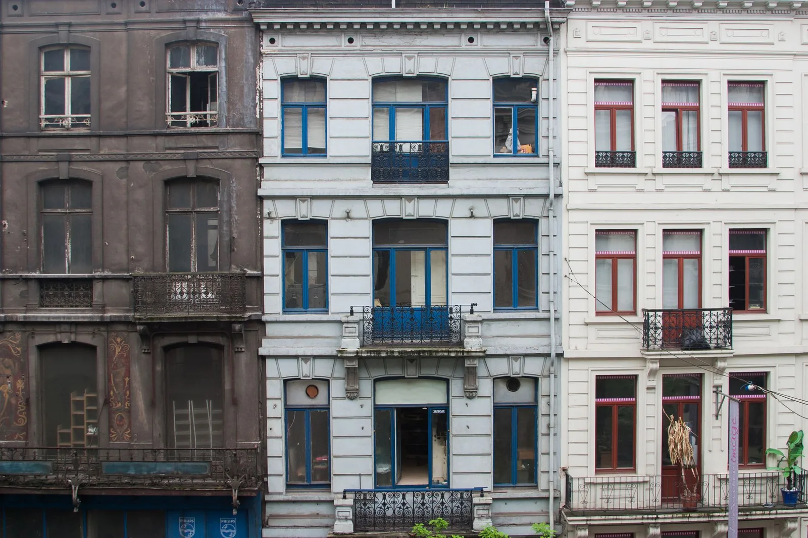 Trois façades de maisons de ville du XIXe siècle à balcons en fer forgé, à Bruxelles