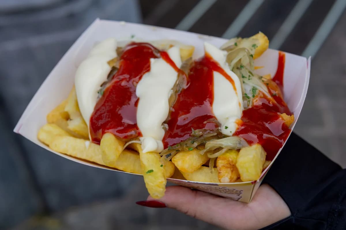 Cornet de frites belges avec deux sauces sur le comptoir d'une friterie