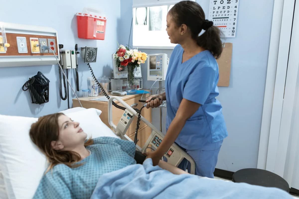 Une infirmière règle le matériel au chevet d'une patiente dans une chambre d'hôpital
