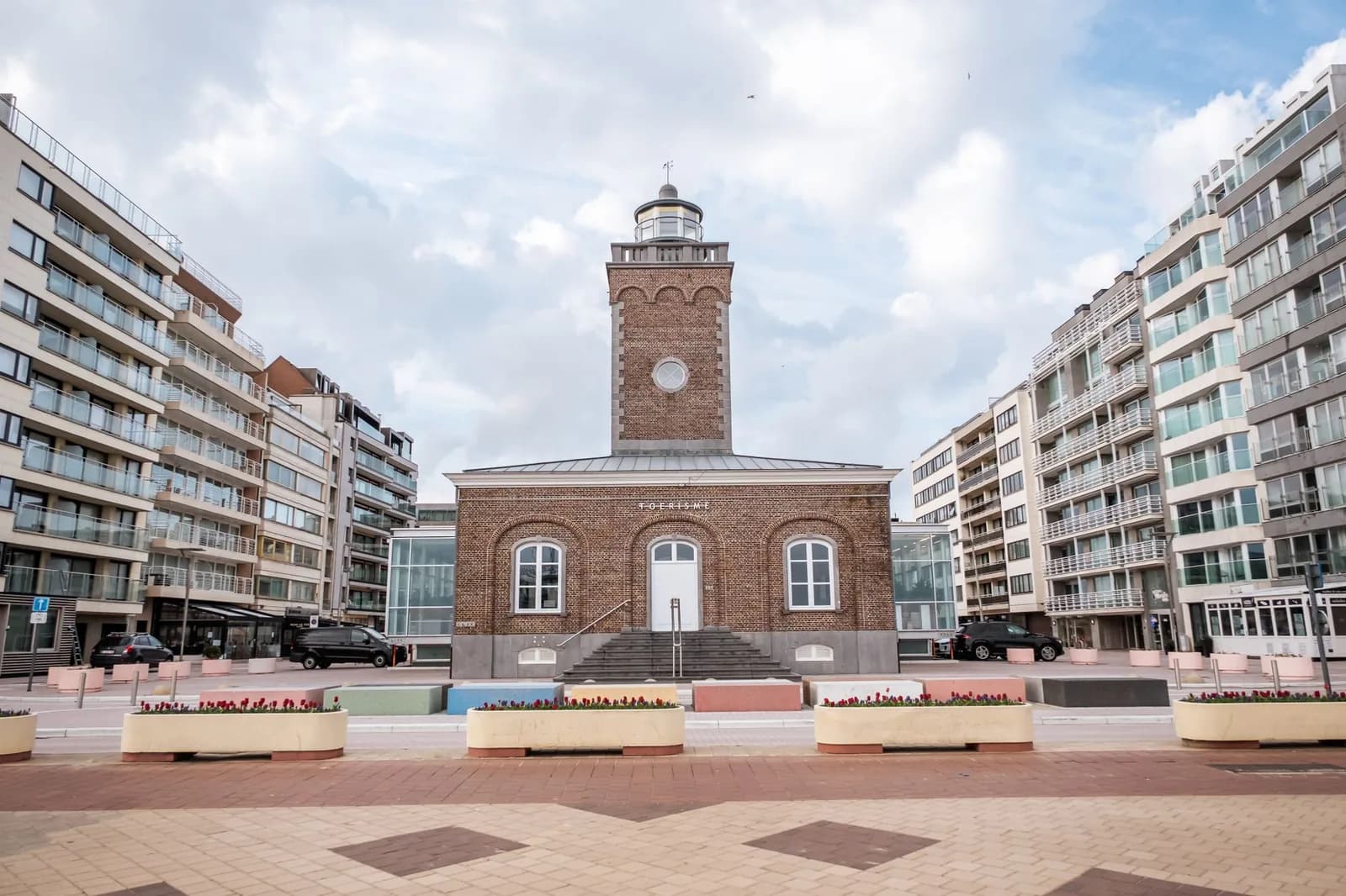 L'ancien phare de brique de la Lichttorenplein à Knokke, qui abrite l'office du tourisme, entre deux rangées d'immeubles modernes