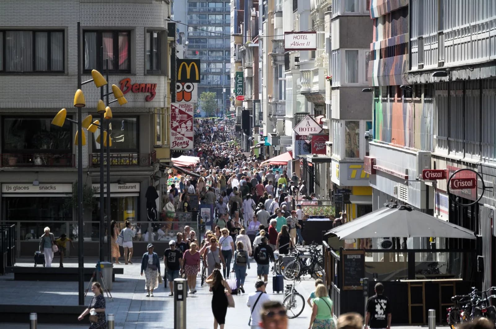 Foule dans la Kapellestraat, rue commerçante piétonne d'Ostende, bordée d'enseignes, de restaurants et d'hôtels