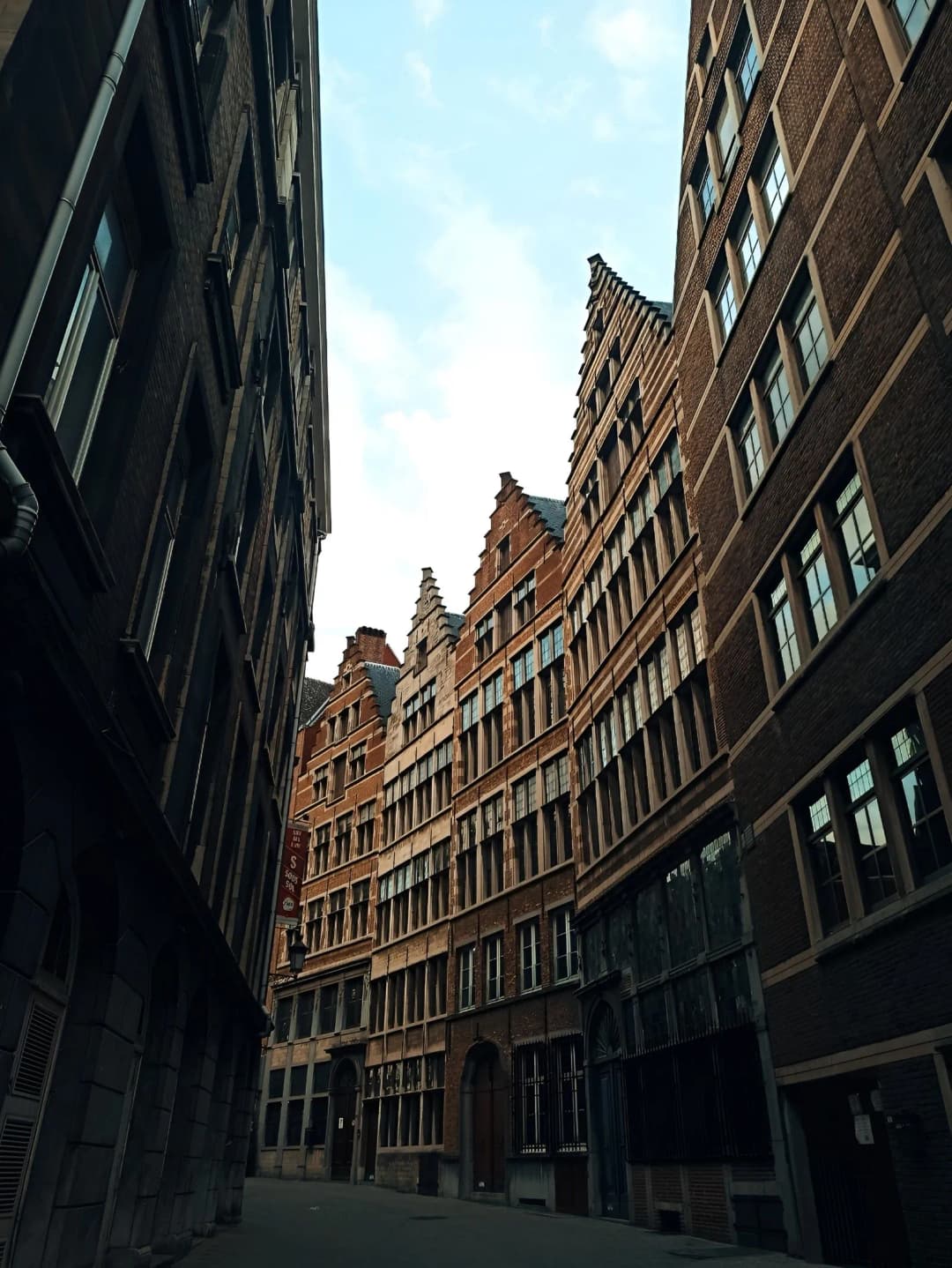 Rue étroite bordée de maisons en brique à pignons à redents