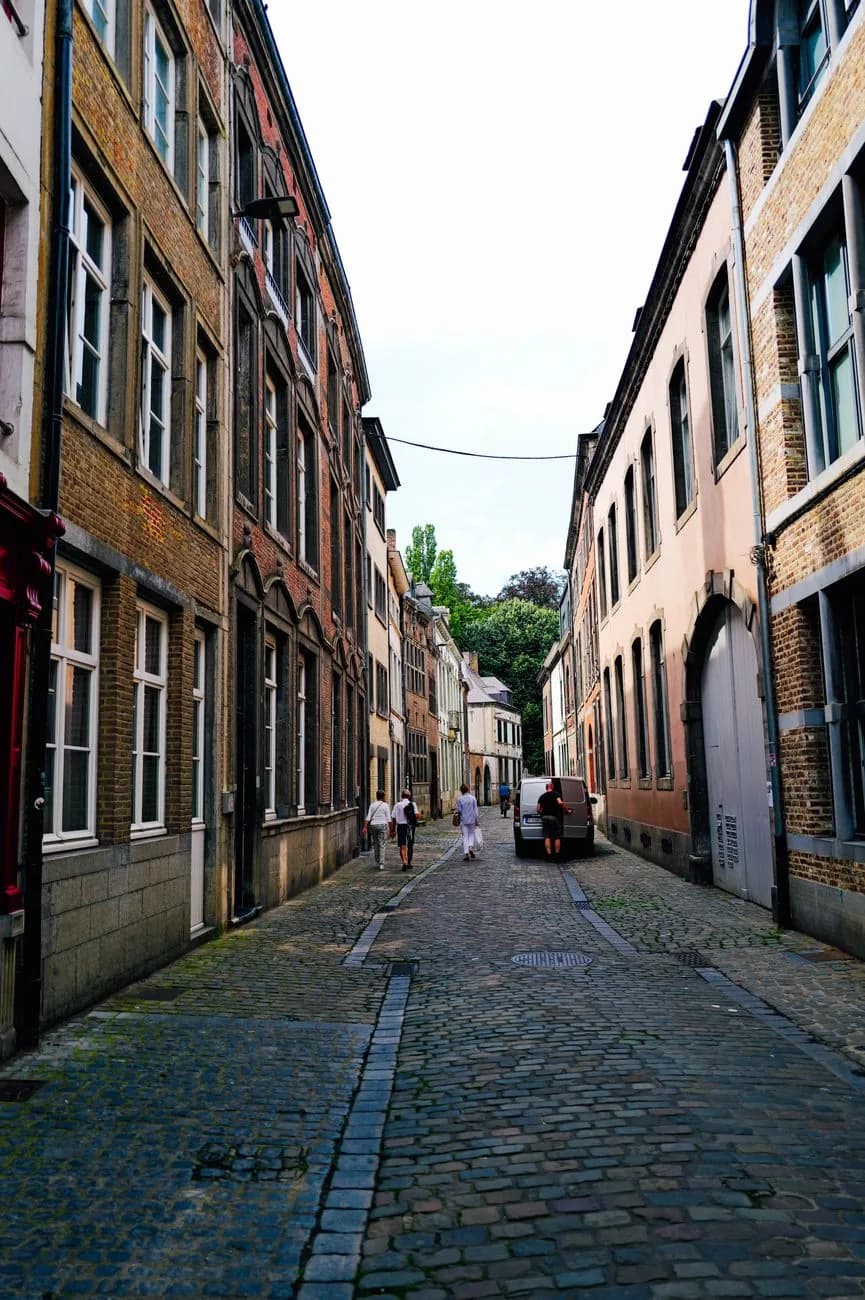 Ruelle pavée étroite bordée de maisons anciennes en brique et pierre