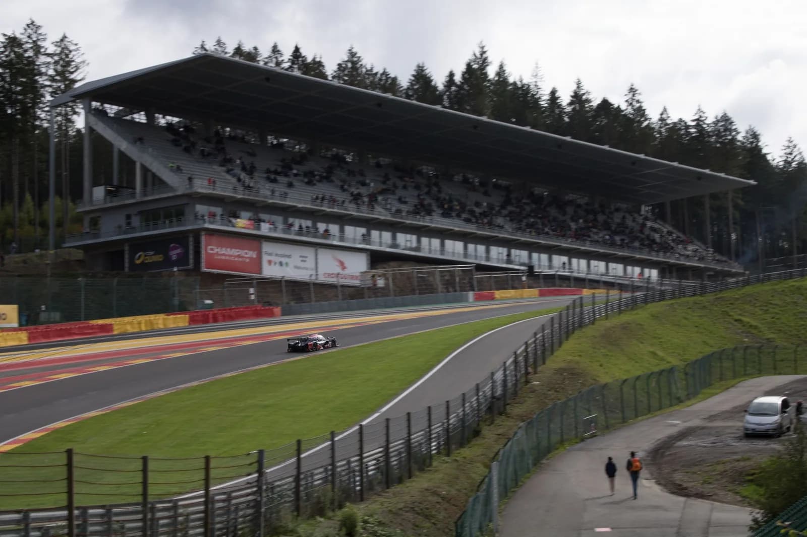 La tribune principale du circuit de Spa-Francorchamps, ses vibreurs rouge et jaune et la sapinière ardennaise