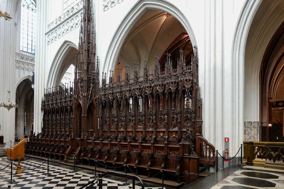 Stalles en bois finement sculptées dans le chœur d'une cathédrale gothique aux murs blancs