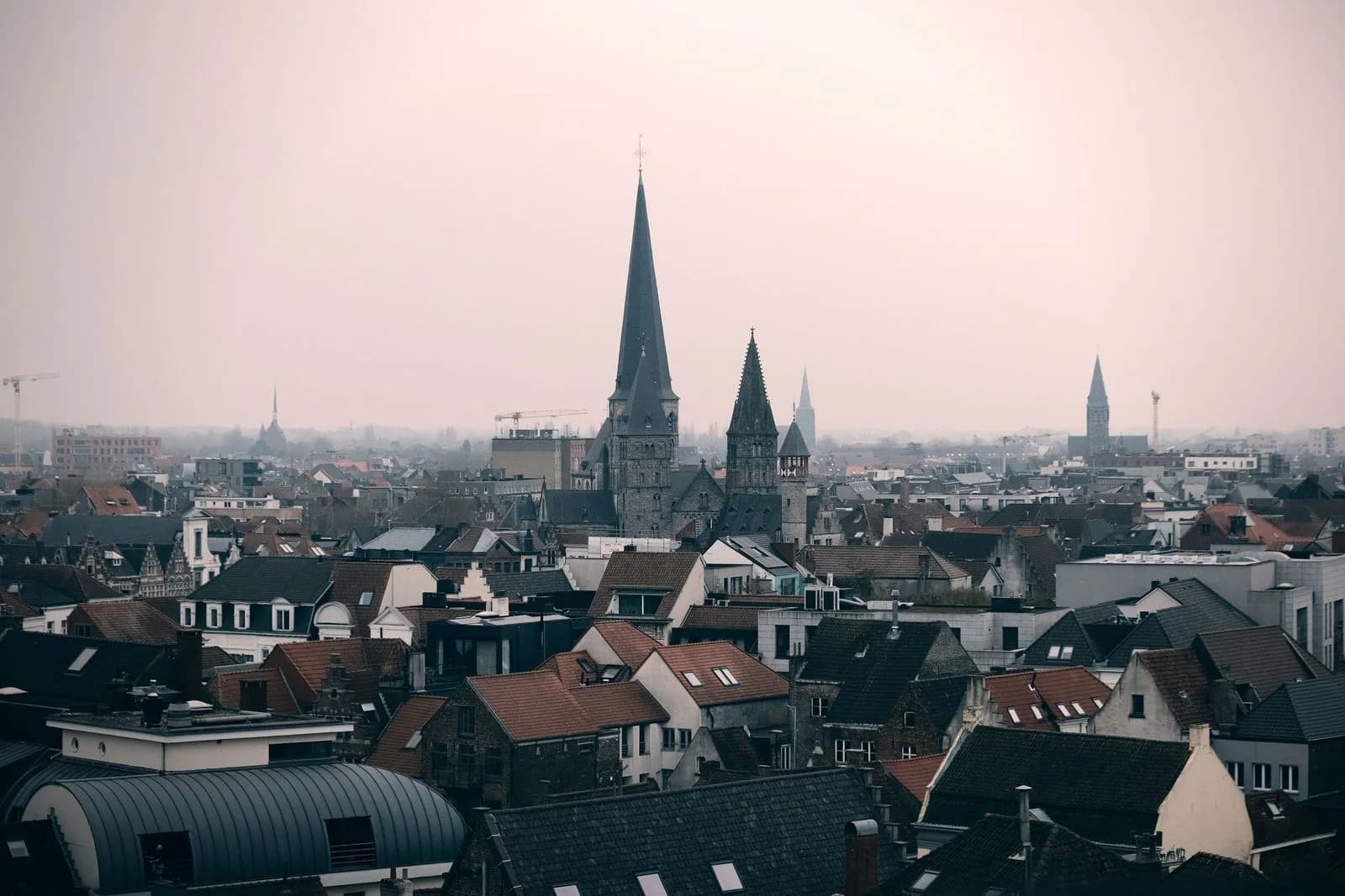 Toits de tuiles et clochers d'une ville flamande dans la brume